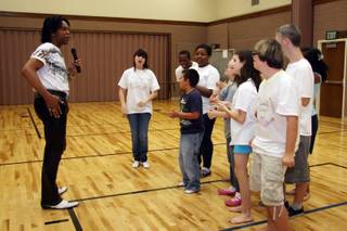 Popular singer Phil Flowers, left, instructs the students of Life Long Dreams during rehearsals at the Church of Jesus Christ of Latter-day Saints gym.