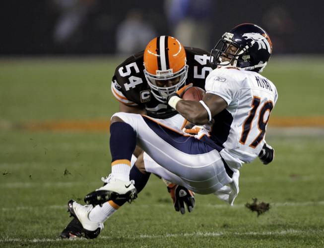 Denver Broncos wide receiver Eddie Royal (19) is tackled by Cleveland Browns linebacker Andra Davis (54) during an NFL football game Thursday, Nov. 6, 2008, in Cleveland. 