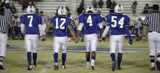 The captains for the Basic Wolves walk out for the coin toss before Friday's game against Valley.