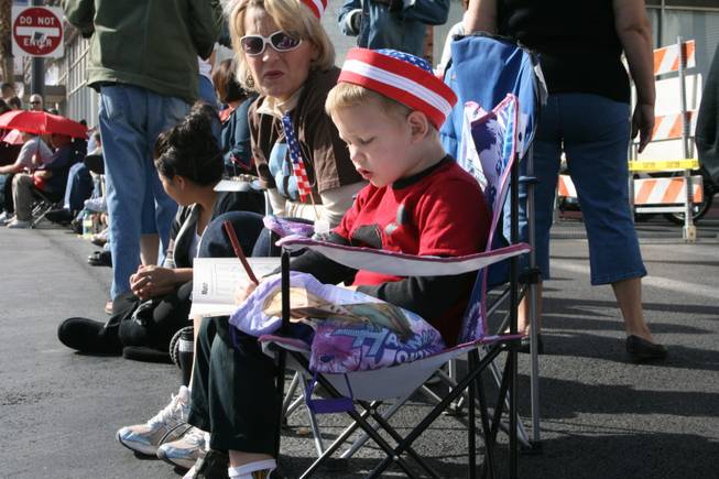 Five-year-old Carson Hersh sits with his mom, Sonya Hersh, as they await the start of the Veterans Day parade downtown Tuesday.