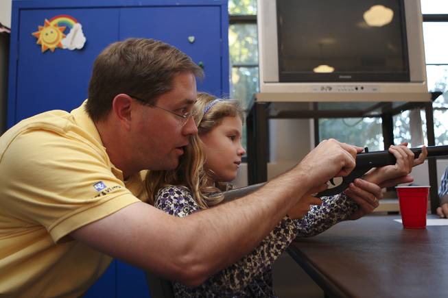 First-grader Elise Hawkins receives a lesson from her dad, Eric, on how to use the gunsight on the BB gun before competing for the first time Tuesday in the annual Turkey Shoot at the Boulder City Recreation Center.