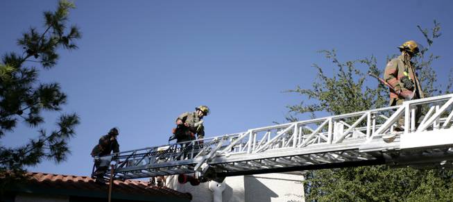 Firefighters climb down the later after extinguishing a blaze that ignited Wednesday morning at the Alexis Heights Condos, 5158 S. Jones Drive, in the southwest valley. Four residents were displaced and two people suffered minor injuries.

