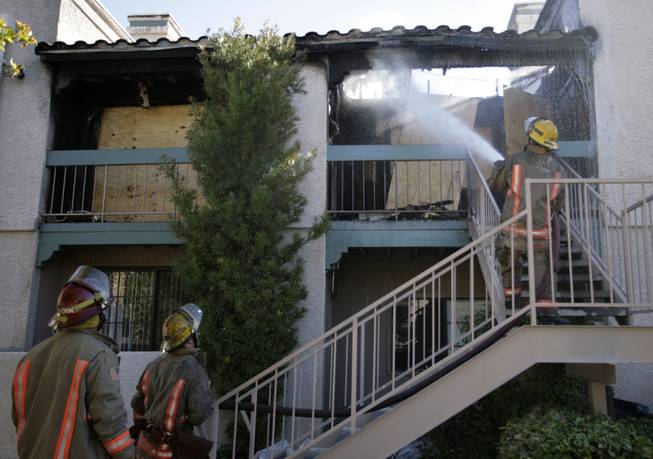 Firefighters extinguish a blaze that ignited Wednesday morning at the Alexis Heights Condos, 5158 S. Jones Drive, in the southwest valley. Four residents were displaced and two people suffered minor injuries.

