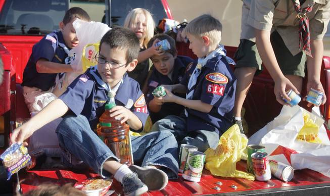 Alec Neitz, from Pack 614, sorts canned food as part of the Scouting for Food drive at the Henderson Salvation Army on Saturday.