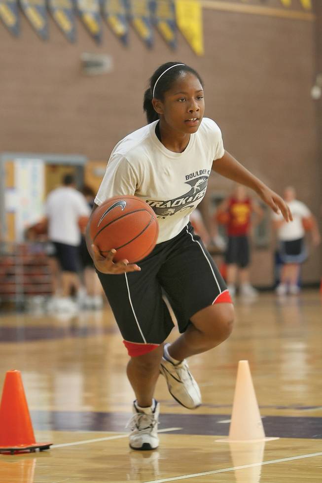 Weaving in and out of cones, senior Endea Dawson runs dribbling drills during the first week of practice at Boulder City High.