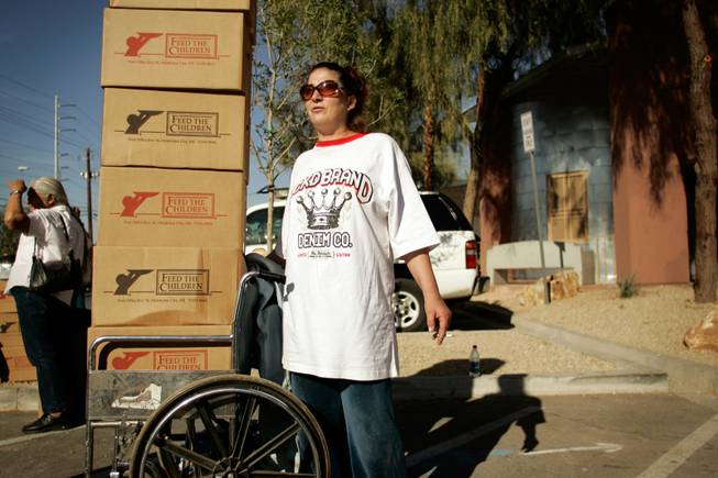 Debra Loeb waits for her ride Monday, her boxes of food piled up on her sister-in-law's wheelchair. The istribution was thanks to a group from locally based ChoiceCenter Worldwide University that had raised $57,000.