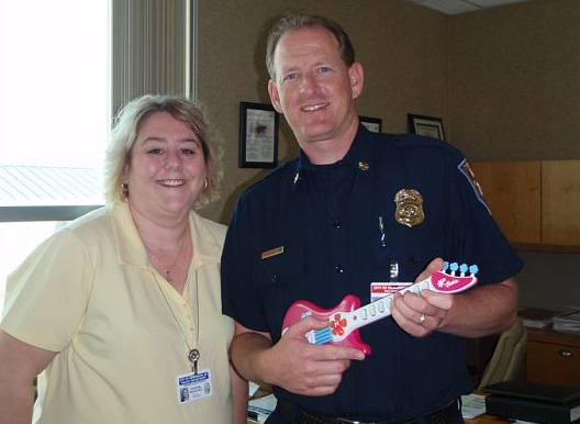 Christina with Fire Chief Doug Stevens during the scavenger hunt, which included getting a photo with the Chief holding a pink Barbie guitar.