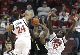 Rene Rougeau and Brice Mussamba play defense on Demerius Ward of Western Michigan at the Orleans Arena, where UNLV took on Western Michigan on Sunday afternoon. UNLV won 70-61.
	


