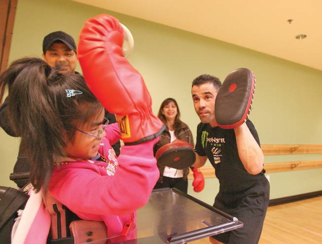 Volunteer Luis Amelburu, right, shadowboxes with Clarabelle Javier, 11, during the year's final Paralympic Academy event at the Henderson Multigenerational Center Dec. 10.