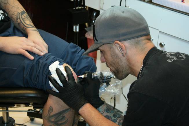11:40 p.m.: A Hart and Huntington tattoo artist works his artistic and inky magic on New Year's Eve.
