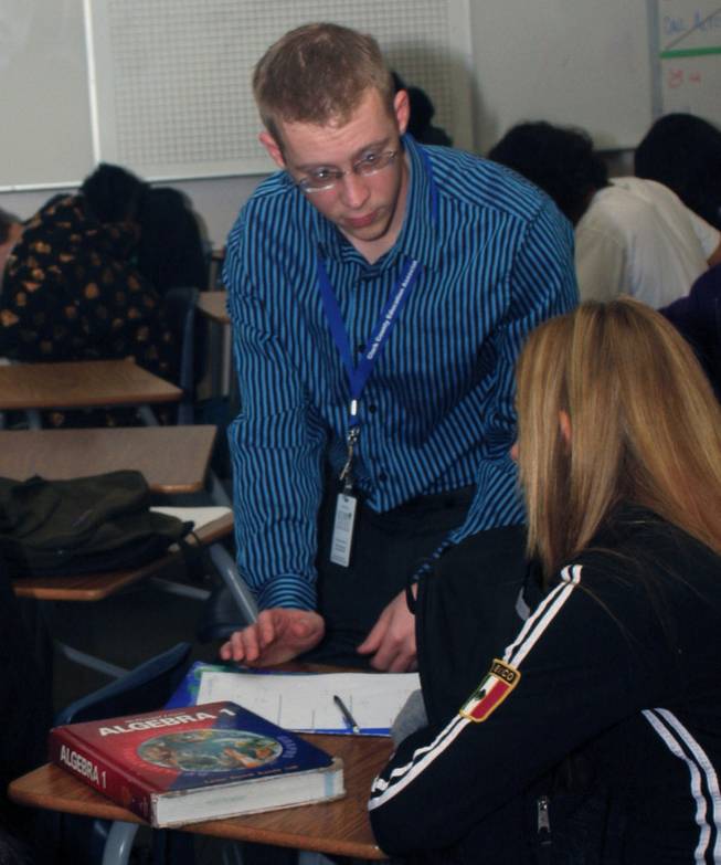 New Green Valley High School teacher Josh Adams makes his way through the classroom during his fifth period Applied Algebra IB class to help students with questions in preparation for a quiz.