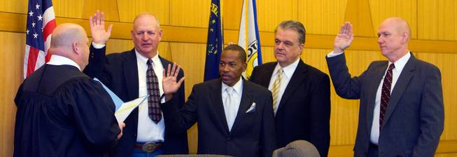 Chief Judge Art Ritchie, left, of 8th Judicial Court, swears in county commissioners (left to right) Tom Collins, Lawrence Weekly, Steve Sisolak and Larry Brown on Monday at the Government Center in Las Vegas.
