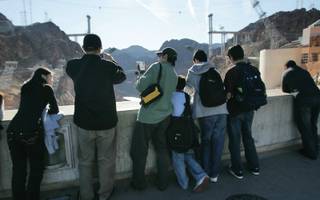 Tourist take photographs from the top of Hoover Dam.