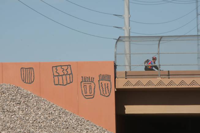 A cyclist crosses a bridge Wednesday at Sahara Avenue and Interstate 215. The bridge is among the first five built with decoration, back when planners were skeptical and the contractor had to put up money to cover the extra cost.