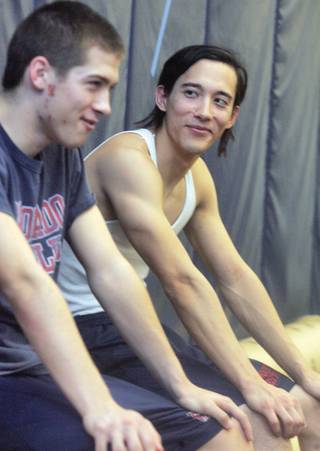 Coach Matt Nishimoto, right, talks with Jacob Ito, left, during wrestling practice on Friday.