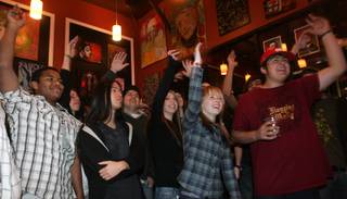 Spectators wave their hands to the music of Dyslexic Duo at Canvas Cafe, 430 E. Silverado Ranch Blvd., during a pre-Inauguration Day event.