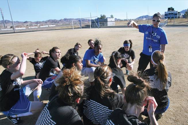 Basic girls' soccer coach Ashley Perez talks to her team during practice.
