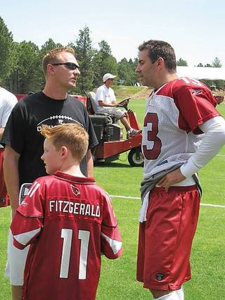 Arizona Cardinals' quarterback Kurt Warner, right, visits with former college teammate Jake Kothe and his son, Elijah, left foreground.