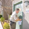 Constable Earl Mitchell locks the door to a residence during an eviction Tuesday in Henderson.