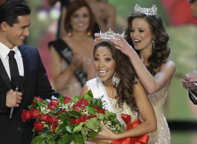 Miss Virginia Caressa Cameron reacts as she is crowned by 2009 Miss America Katie Stam during the 2010 Miss America Pageant at Planet Hollywood. Host Mario Lopez, left, looks on.