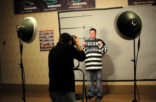 John Grote gets his photo taken at the prison booth during "Rod Blagojevich Prison Uniform Night" Friday as the Wranglers take on the Bakersfield Condors at the Orleans Arena.