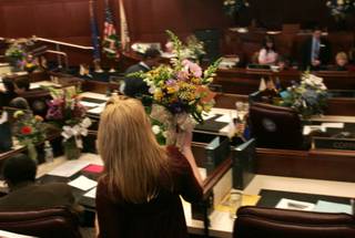 A legislative assistant delivers flowers to the Senate floor on the first day of the 2009 legislative session Monday in Carson City. 