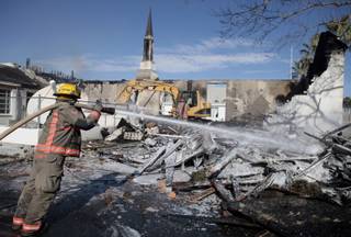 Firefighters spray water on the remains of the Church of Jesus Christ of Latter-day Saints in Logandale on Wednesday. Clark County fire spokesman Scott Allison said there was no immediate indication of foul play in the 4 a.m. fire that engulfed the church.