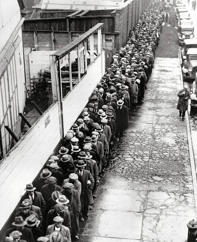 Jobless and homeless men line up to get a free dinner at New York's municipal lodging house in 1932, during the Great Depression.