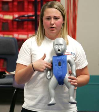 Ashlee Wellman, a lifeguard with Las Vegas Lifeguards 2U, demonstrates how to give lifesaving CPR on a  dummy during a CPR training class for parents and students at Roger D. Gehring Elementary School Wednesday.
