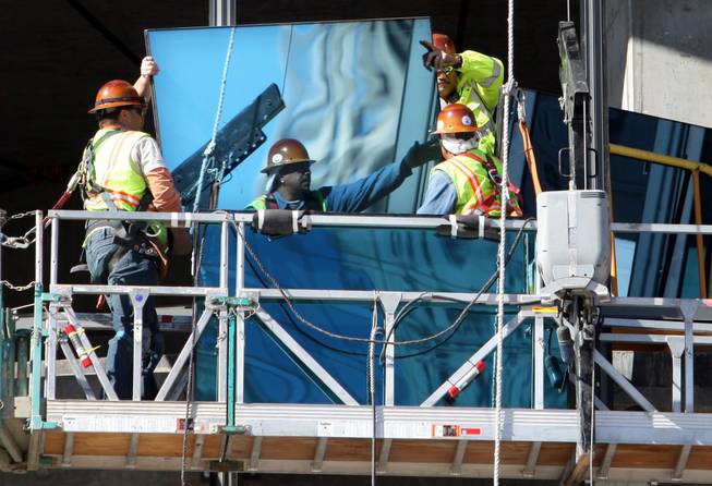 Workers move a piece of exterior glass into place Wednesday during construction of the Harmon at MGM Mirage's CityCenter on Wednesday. It's unclear how much of the building's design will have to be changed.