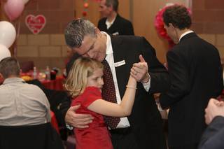 Lily Pellegrini, 9, enjoys a slow dance with her father, Luciano, at the Father-Daughter Valentine's Day Dance at Alexander Dawson School at Rainbow Mountain on Friday.