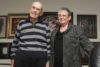 Howard and Helene Moore lead a tour of the 800-piece kissing art collection in their home for members of the Henderson Senior Center on Wednesday.