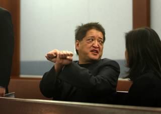 Terrance K. Watanabe, 52, of Omaha, Neb., talks with a woman (identified as a sister) and attorneys before his appearance in court at the Regional Justice Center in Las Vegas on Wednesday. Watanabe, in a negotiated deal, posted $1.5 million and turned himself in for processing. According to prosecutors, the high-rolling philanthropist owes $14.7 million to Caesars Palace and the Rio, which are owned by Harrah's Entertainment Inc.