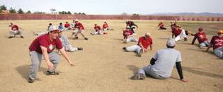 Members of the Del Sol baseball team stretch out at the beginning of practice.