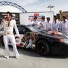 Elvis Presley impersonator Harry Shahoian and members of The Flying Elvi skydiving team show off a Dale Earnhardt and Elvis Presley-themed racecar at Las Vegas Motor Speedway on Friday, Feb. 27, 2009. 