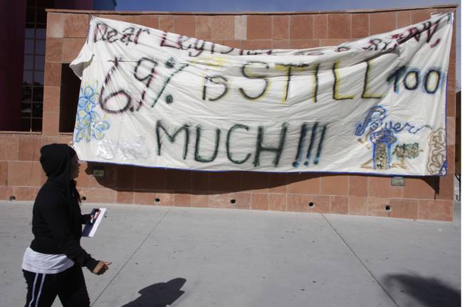 A student passes by a banner hung by students outside a regents meeting at the College of Southern Nevada, Charleston campus Thursday, March 3, 2010.