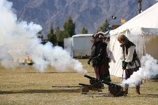 Steve Baer, right, and Nathanial Davidson set off black powder cannons during the Renaissance Faire at Veterans Memorial Park on Friday. The event runs through Sunday.