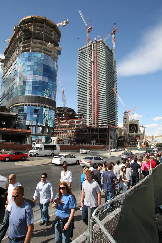 Pedestrians pass by the Harmon, left, part of MGM Mirage's CityCenter project, and the Cosmopolitan, right, on the Las Vegas Strip in March.