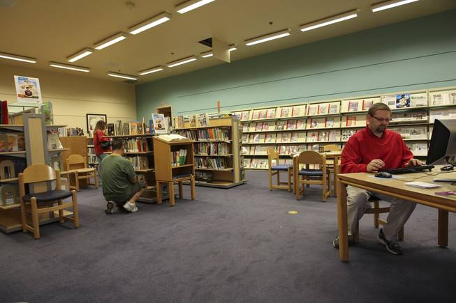 As Alex Quihuis, left, looks for a book to read, John Heffner, right, works on the computer  while visiting the open annex of Green Valley Library.  Renovation of the main library is expected to be completed by late April.
 The Henderson Library District has been working on renovating the branch since assuming control of it Jan. 1 from the Las Vegas-Clark County Library District.