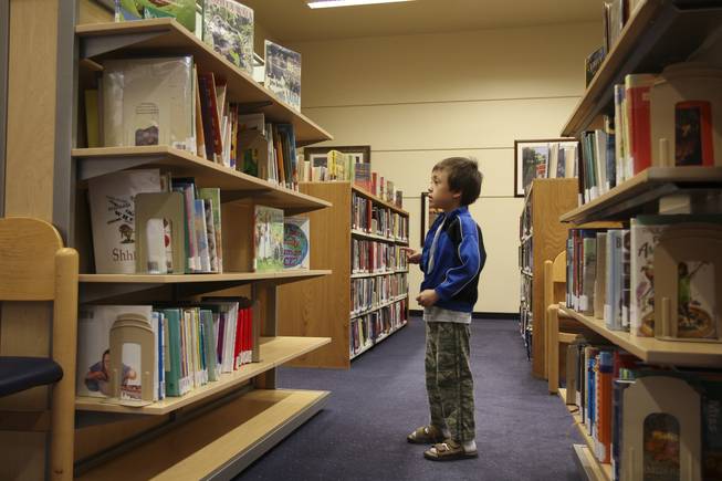 Ty Moeslacher searches for a children's book in the open annex of Green Valley Library.  The Henderson Library District has been working on renovating the branch since assuming control of it Jan. 1 from the Las Vegas-Clark County Library District.