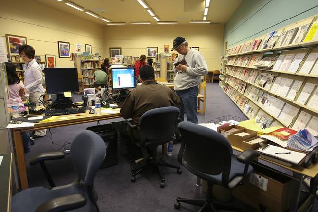 Senior circulation specialist Justin Viskoc assists Philip Dore in getting a library card Monday in the open annex of Green Valley Library. The Henderson Library District has been working on renovating the branch since assuming control of it Jan. 1 from the Las Vegas-Clark County Library District.