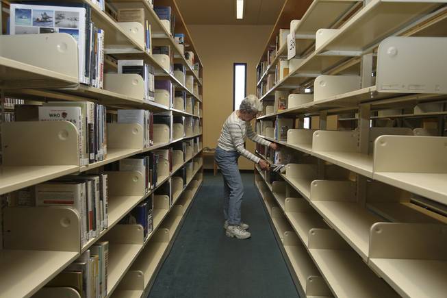 Volunteer Barb Donohoe places books on shelves Monday in the renovated aisles of Green Valley Library. The Henderson Library District has been working on renovating the branch since assuming control of it Jan. 1 from the Las Vegas-Clark County Library District.