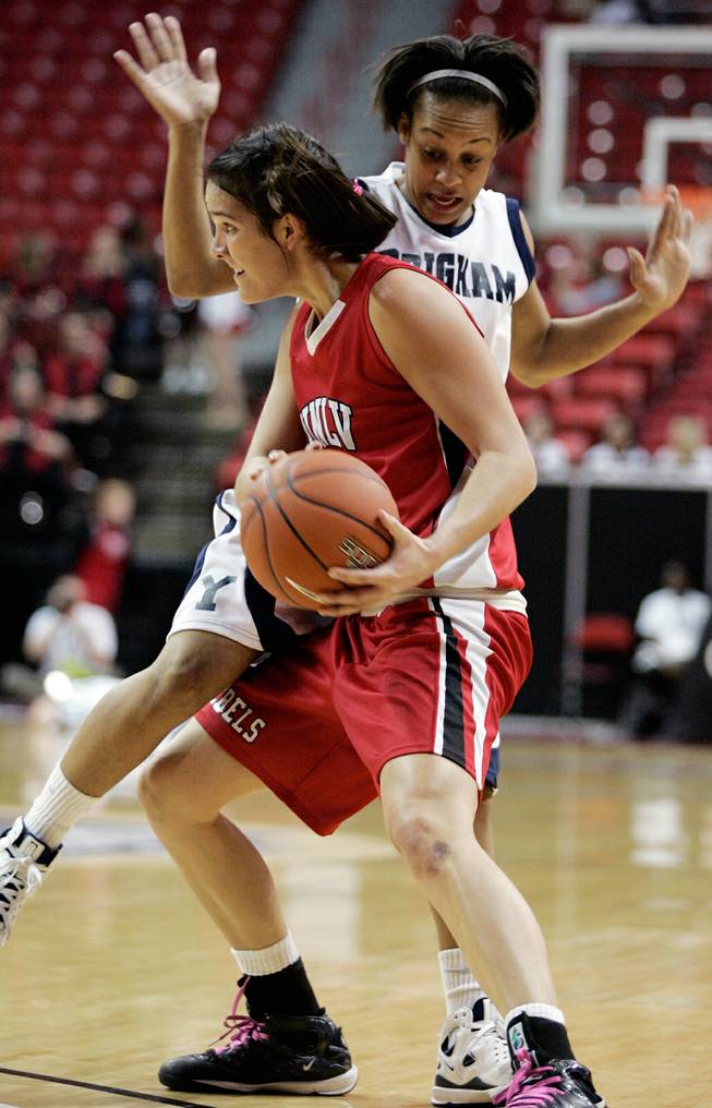 Jamie Smith of UNLV tries to pass the ball around the defense of Jazmine Foreman of BYU during the first round of the Mountain West Championship at the Thomas & Mack Center in Las Vegas on Tuesday. UNLV won the game 66-58. 