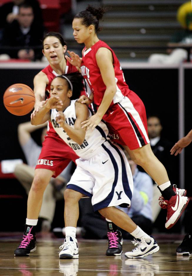 Jazmine Foreman, center, of BYU struggles against the defense of UNLV's Jamie Smith, left, and Erica Helms, right, during the first round of the Mountain West Championship at the Thomas & Mack Center in Las Vegas on Tuesday. UNLV won the game 66-58. 