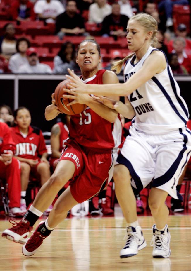 Erica Helms, left, of UNLV dribbles past Stephanie Buhler of BYU during the first round of the Mountain West Championship at the Thomas & Mack Center in Las Vegas on Tuesday. UNLV won the game 66-58. 