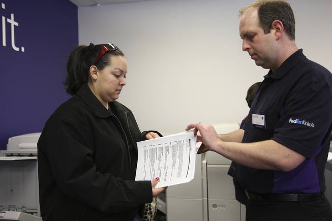 Maylean Her, 23, checks the printing of her resumes with FedEx associate Marshal Nix. Her said she is seeking a job in customer service. FedEx Office locations nationwide, including the one at 671 Mall Ring Circle in Henderson, offered job seekers free printing of 25 resumes on premium papers Tuesday during "FedEx Office's Free Resume Printing Day."