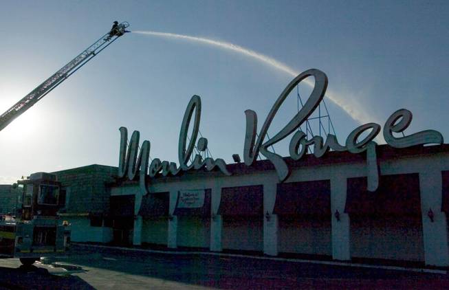 Las Vegas firefighter Jeff Alverson is silhouetted against the afternoon sky as he directs a master stream of water onto the smoldering remains of the Moulin Rouge Thursday, May 29, 2003. A three-alarm fire destroyed the casino earlier in the day. 
