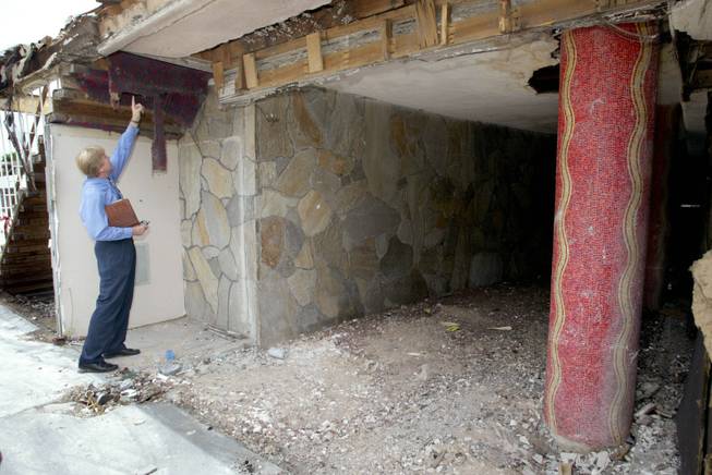 Robert Holgate, director of Forward Planning for the Moulin Rouge Development Corporation, points to a piece of original carpeting as he looks over the remains of the historic Moulin Rouge Casino on Bonanza Road Tuesday, August 26, 2003. Mosaic columns, right, also survived. Fire destroyed the casino May 29, 2003.