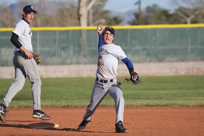 Boulder City's second baseman Ryan Washburn throws to first as third baseman Ross LaMarca, left, covers second during infield practice in preparation for the upcoming season.