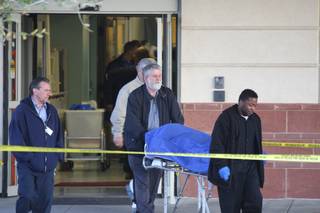 Valley Funeral Home attendants remove the body of the man who police say they shot after he threatened them with a gun. The emergency room at St. Rose - Siena Hospital, where the shooting took place, remained closed Wednesday morning.